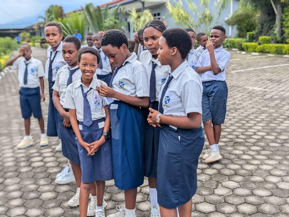 Upper-primary pupils chatting and smiling outdoors during an educational visit