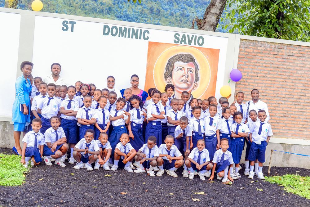 Pupils and teachers gathered in front of the St Dominic Savio mural on the school wall